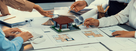 Group of interior designer team in meeting, discussing with engineer on interior design and planning for house project blueprint and model, choosing color sample and mood board materials. Insightの写真素材