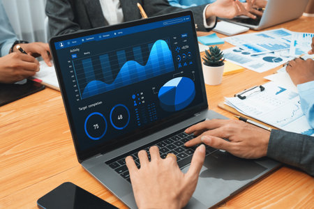 Multiracial analyst team use BI Fintech software to analyze financial data on meeting table....