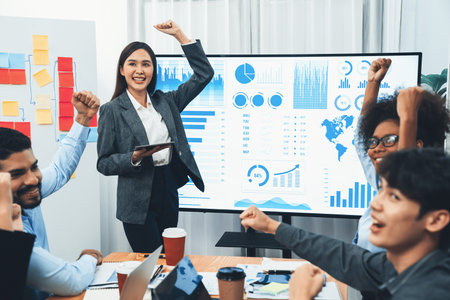 Business people celebrate after successful presentation or meeting on data analysis display on TV...
