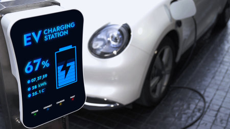 Electric car recharging with EV charger from charging station at public car park. Future innovative rechargeable EV car using alternative clean and sustainable energy. Peruseの写真素材