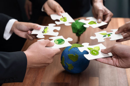 Cohesive group of business people holding eco icon jigsaw puzzle pieces around globe Earth as eco corporate responsibility for community and sustainable solution for greener Earth. Quaintの写真素材