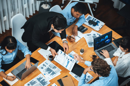 Wide top view of diverse group of business analyst team analyzing financial data report paper on meeting table. Chart and graph dashboard by business intelligence analysis. Meticulousの写真素材
