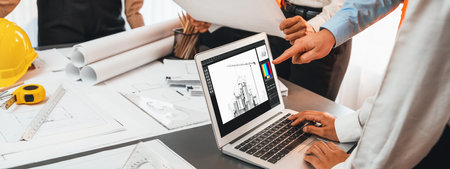 Engineer and architect working together brainstorming and designing blueprint using laptop working with architectural software for precise digital interior or structure design. Insightの写真素材