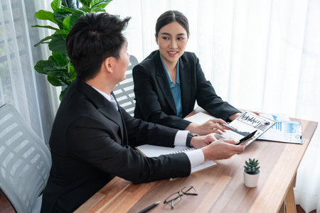 Busy analyst team in office discuss data analysis and marketing strategy using BI dashboard and statistics display on tablet screen to improve business performance at meeting with teamwork. Jubilantの写真素材