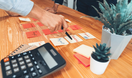 Business team gather on table, brainstorming and writing creative idea on colorful post-it notes. Planning and brainstorm strategy to achieve business targets. ferventの写真素材