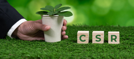Businessman holding plant pot with cube symbolizing CSR. Ethical and eco-friendly green business with no CO2 emission policy. Committed to corporate social responsibility for greener community. Alterの写真素材