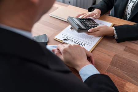 Real estate agent review tax and interest calculation, insurance agreements terms with client for property purchase and house loan. Financial advisor help clients manage investment budget. Jubilantの写真素材