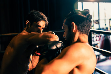 Asian and Caucasian Muay Thai boxer unleash elbow attack in fierce boxing match. Thai boxer with strong muscular body exchanging punch and elbow strike with relentless combat prowess. Impetusの写真素材