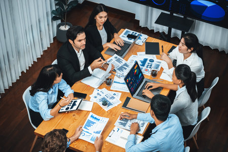 Wide top view of diverse group of business analyst team analyzing financial data report paper on meeting table. Chart and graph dashboard by business intelligence analysis. Meticulousの写真素材