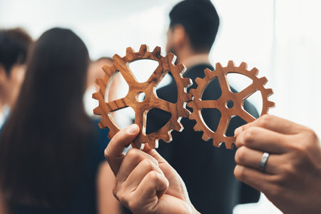 Office worker holding cog wheel as unity and teamwork in corporate workplace concept. Diverse...