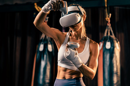 Female boxer training with VR or virtual reality, wearing VR headset with immersive boxing training technique using controller to enhance her skill in boxing simulator. Impetusの写真素材