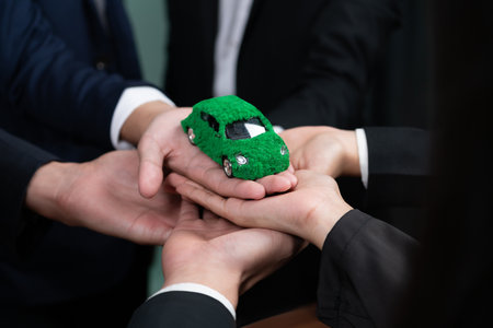 Business people holding EV car model as business synergy partnership unite and take action to...