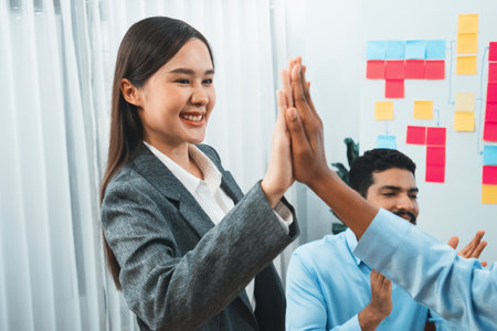 Diverse business team celebrate successful meeting with high-fives and expressions of happiness in corporate office meeting represent unity success and professional integrity. Concordの写真素材