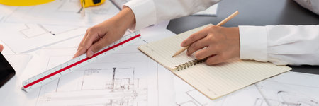 Architect or engineer working on building blueprint, contractor designing and drawing blueprint...
