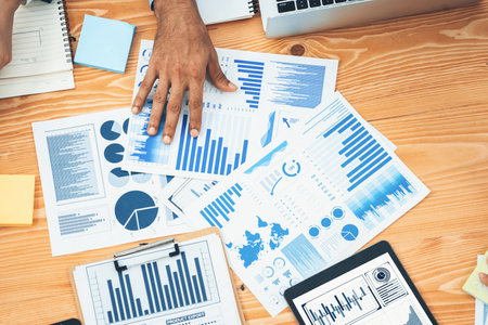 Flat top view workspace wooden table with analyst team use BI dashboard papers data for planning...