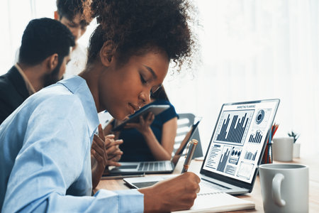Young african businesswoman working together and discussing in corporate office with multicultural coworkers. Professional and diversity teamwork discuss business plan on desk. Concordの写真素材
