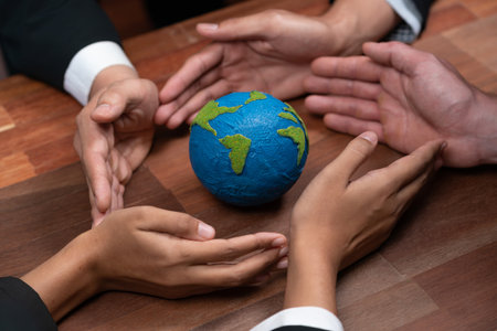 Top view business people holding Earth together in synergy as team building to utilize eco regulation for environmental protection by reducing CO2 emission to save Earth. Quaintの写真素材