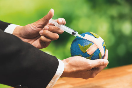 Businessman holds and inject medicine to paper earth as symbol of eco environmental awareness and...