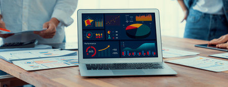 Focus BI power dashboard display on laptop screen with blurred background of analyst team analyzing business financial data using BI Fintech software for business insight. Panorama shot. Scrutinizeの写真素材