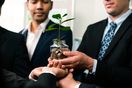 Business people holding money savings jar together in synergy filled with coin and growing plant for sustainable financial for retirement or eco subsidy investment for environment protection. Quaintの写真素材