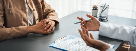 Doctor show medical diagnosis report and providing compassionate healthcare consultation to young patient in doctor clinic office. Doctor appointment and medical consult concept. Neotericの写真素材