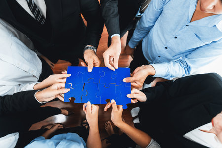 Top view multiethnic business people holding jigsaw pieces and merge them together as effective solution solving teamwork, shared vision and common goal combining diverse talent. Meticulousの写真素材