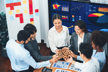 Office worker holding cog wheel as unity and system teamwork in corporate workplace with piles of...