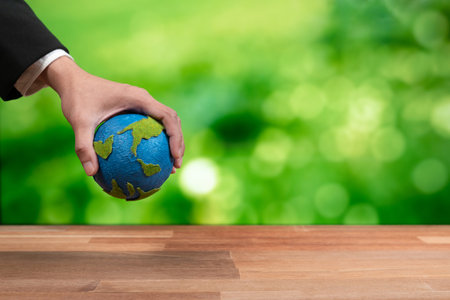 Businessman holds paper earth as symbol of eco environmental awareness for sustainable world using clean energy and zero CO2 emission. Eco-friendly corporate with go green policy to save earth. Alterの写真素材