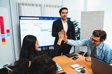 Cheerful meeting room, businesspeople celebrate with high fives and applause. Successful project was...