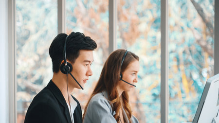 Business people wearing headset working in office to support remote customer or colleague. Call center, telemarketing, customer support agent provide service on telephone video conference call. Jivyの写真素材