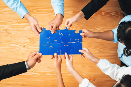 Top view multiethnic business people holding jigsaw pieces and merge them together as effective solution solving teamwork, shared vision and common goal combining diverse talent. Habilimentの写真素材