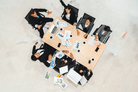 Successful business people celebrate together with joy at office table shot from top view . Young businessman and businesswoman workers express cheerful victory showing success by teamwork . Jivyの写真素材