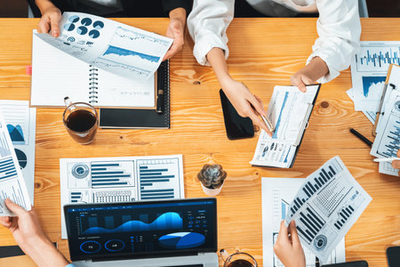 Top view diverse group of business analyst team analyzing financial data report paper on meeting table. Chart and graph dashboard by business intelligence analysis. Meticulousの写真素材