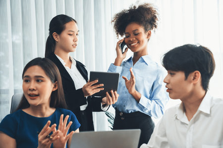 Happy diverse business people work together, discussing in corporate office. Professional and diversity teamwork discuss business plan on desk with laptop. Modern multicultural office worker. Concordの写真素材