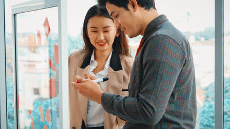 Business people work on project planning board in office and having conversation with coworker friend to analyze project development . They use sticky notes posted on glass to make it organized. Jivyの写真素材