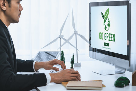 Businessman working in office developing plan or project on eco-friendly alternative energy with solar cell technology display on computer screen for greener environment as apart of CSR effort. Gyreの写真素材