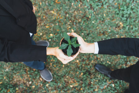 Top view business people holding plant as concept of eco company committed to corporate social responsible, reducing CO2 emission, protect susainable environment, and embrace ESG principle. Gyreの写真素材