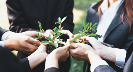 Business people hold plant together in unity and teamwork concept of eco company committed to corporate social responsible, reducing CO2 emission, embrace ESG principle for sustainable future. Gyreの写真素材