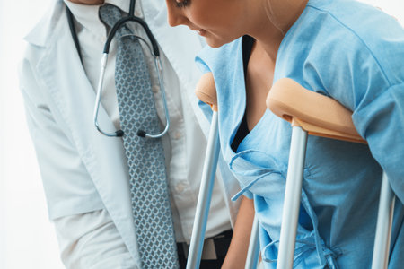 Doctor takes care of patient in crutch at hospital. Physical therapist and leg injury recovery concept. Jivyの写真素材