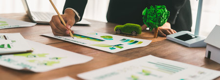 Businessman planning for green business strategy in office with paper documents focused on eco-friendly and energy sustainable policy to reduce CO2 emission for green environment. Trailblazingの写真素材