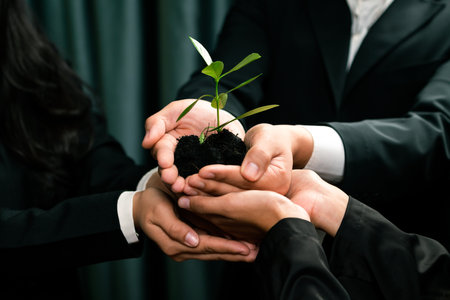 Eco-friendly investment on reforestation by group of business people holding plant together in office promoting CO2 reduction and natural preservation to save Earth with sustainable future. Quaintの写真素材