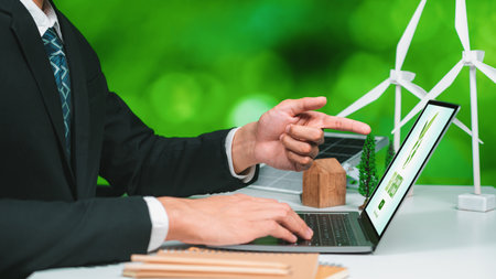 Businessman working in office developing plan or project on eco-friendly alternative energy with solar cell technology display on computer screen for greener environment as apart of CSR effort. Gyreの写真素材