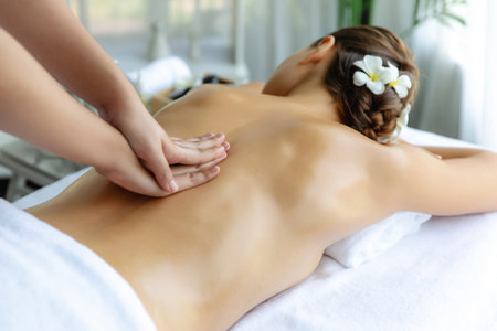 Caucasian woman customer enjoying relaxing anti-stress spa massage and pampering with beauty skin recreation leisure in day light ambient salon spa at luxury resort or hotel. Quiescentの写真素材