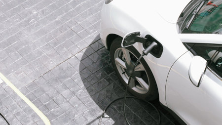 Progressive innovation urban electric on-street charging station with electric vehicle battery being charged with green energy for environmental concern in order to reduce CO2 emission.の写真素材