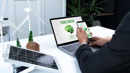 Businessman working in office developing plan or project on eco-friendly alternative energy with solar cell technology display on computer screen for greener environment as apart of CSR effort. Gyreの写真素材