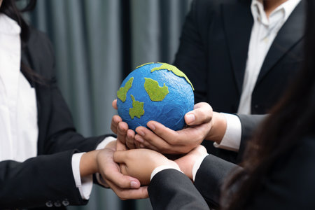 Top view business people holding Earth together in synergy as team building to utilize eco regulation for environmental protection by reducing CO2 emission to save Earth. Quaintの写真素材