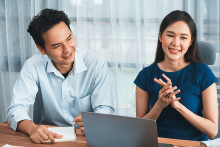 Professional Asian employee work together as team in corporate office, discussing business plans and data to achieve success on desk with laptop. Modern office worker teamwork concept. Concordの写真素材