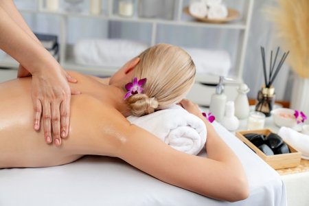 Caucasian woman customer enjoying relaxing anti-stress spa massage and pampering with beauty skin recreation leisure in day light ambient salon spa at luxury resort or hotel. Quiescentの写真素材
