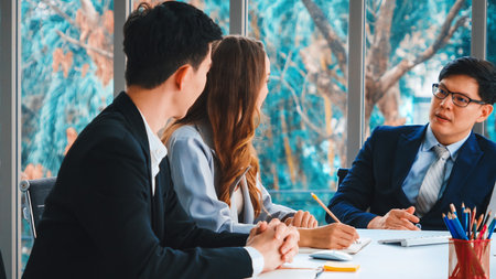 Smart businessman and businesswoman talking discussion in group meeting at office table in a modern office interior. Business collaboration strategic planning and brainstorming of coworkers. Jivyの写真素材