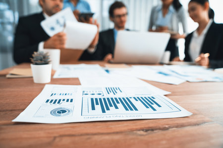 Focus financial data dashboard paper by business intelligence display graph, chart and statistic report on office table with blurred business people working in background. Habilimentの写真素材